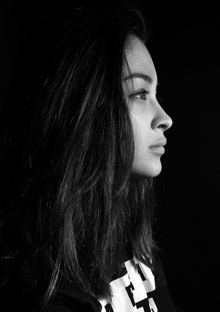 person with long hair showing their profile, black and white portrait 