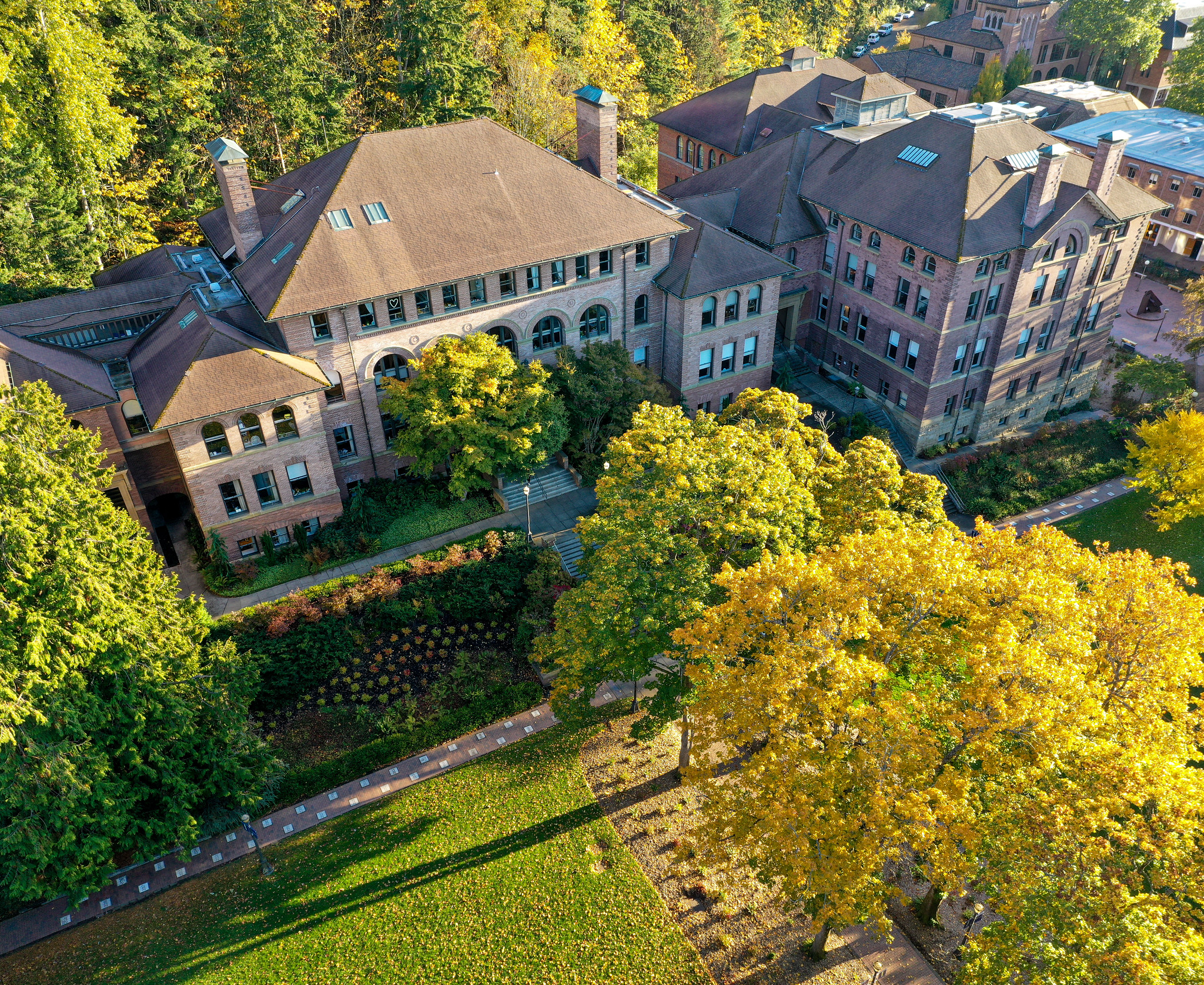 Aerial view of Old Main, a brick building, surrounded by colorful trees